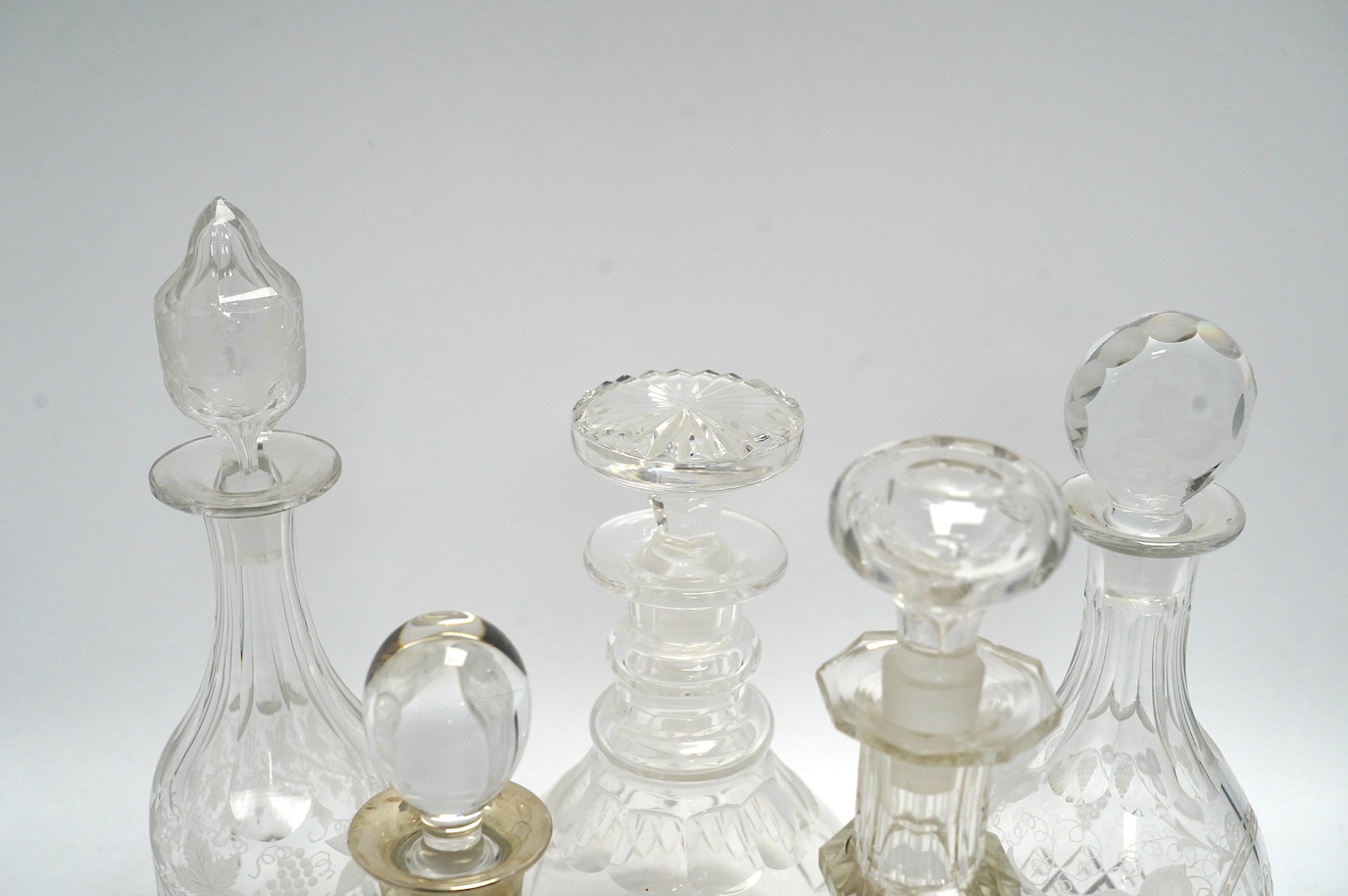 Thirteen Victorian and later glass decanters including three silver mounted examples, tallest 30cm high. Condition - varies, mostly fair
